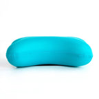 A young child with closed eyes rests their head on a small, dark blue microbead pillow.