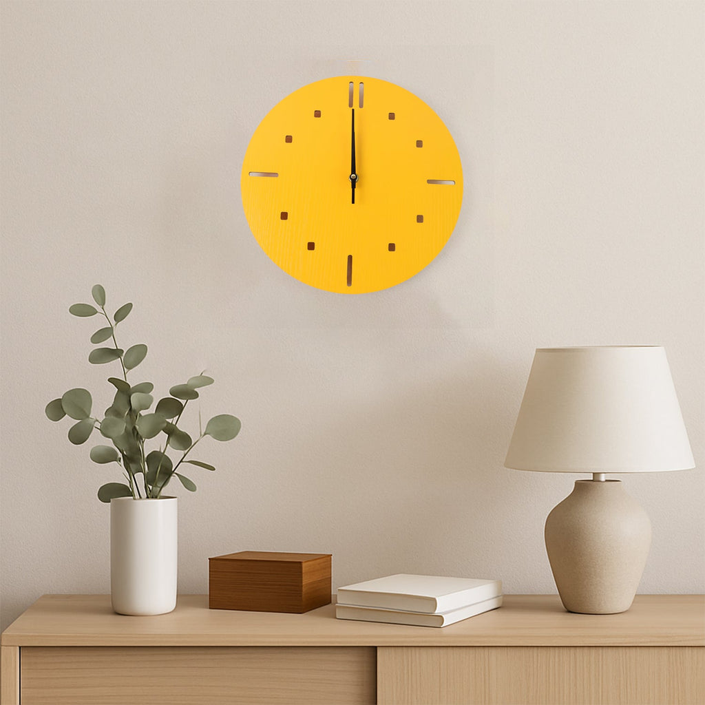 A yellow round wall clock hangs above a wooden console table with a plant, a wooden box, and a lamp.