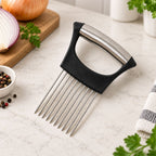 A black and silver onion holder rests on a white counter, with a cut red onion and peppercorns in the background.