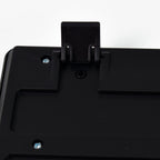 A close-up of the back of a black keyboard showing an extended kickstand and screws.