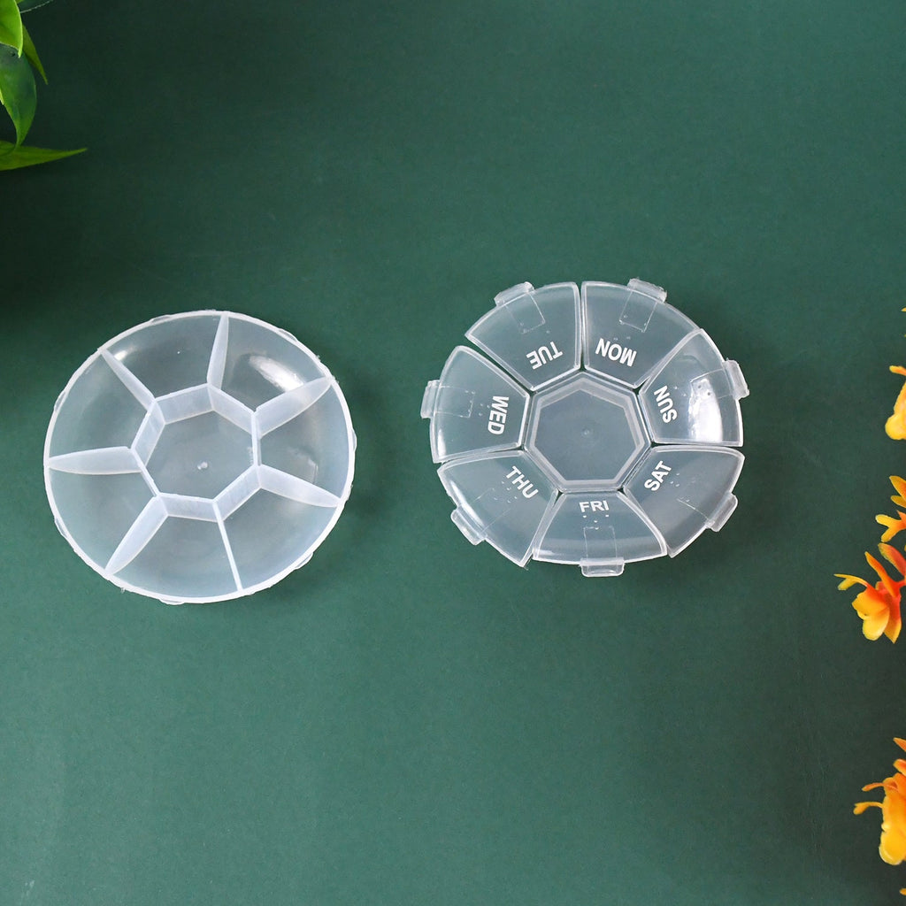 Two clear 7-day pill organizers, one assembled and one disassembled, on a dark green surface.