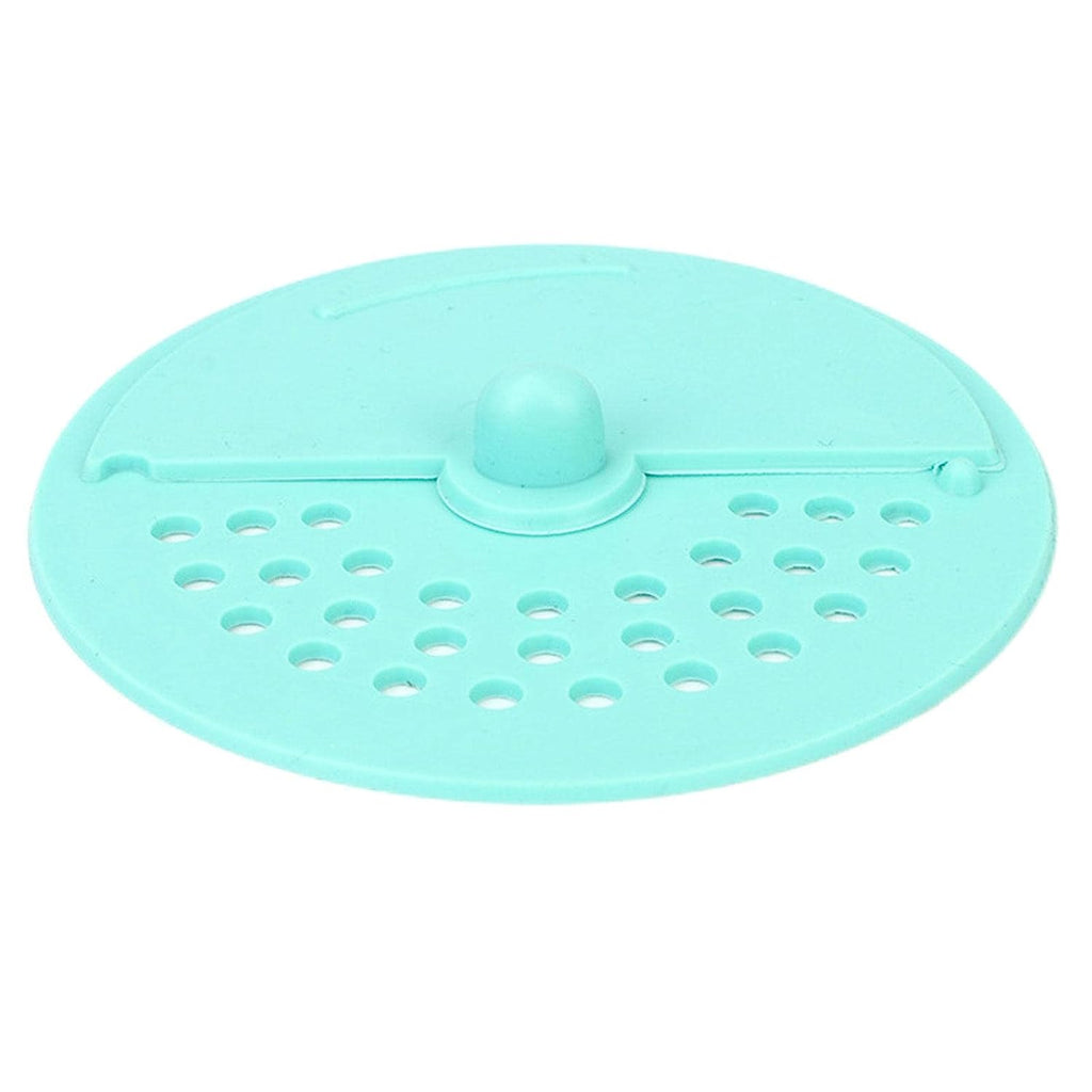 A light green silicone drain strainer with a central knob and two sections of holes is shown from above.