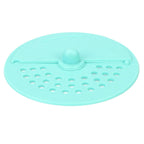 A light green silicone drain strainer with a central knob and two sections of holes is shown from above.