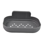 A gray self-adhesive soap dish with diamond-shaped drainage holes is shown on a white background.