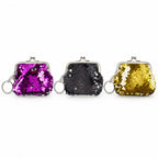 Three sequined coin purse keychains in purple, black, and gold are arranged side-by-side on a plain white surface.