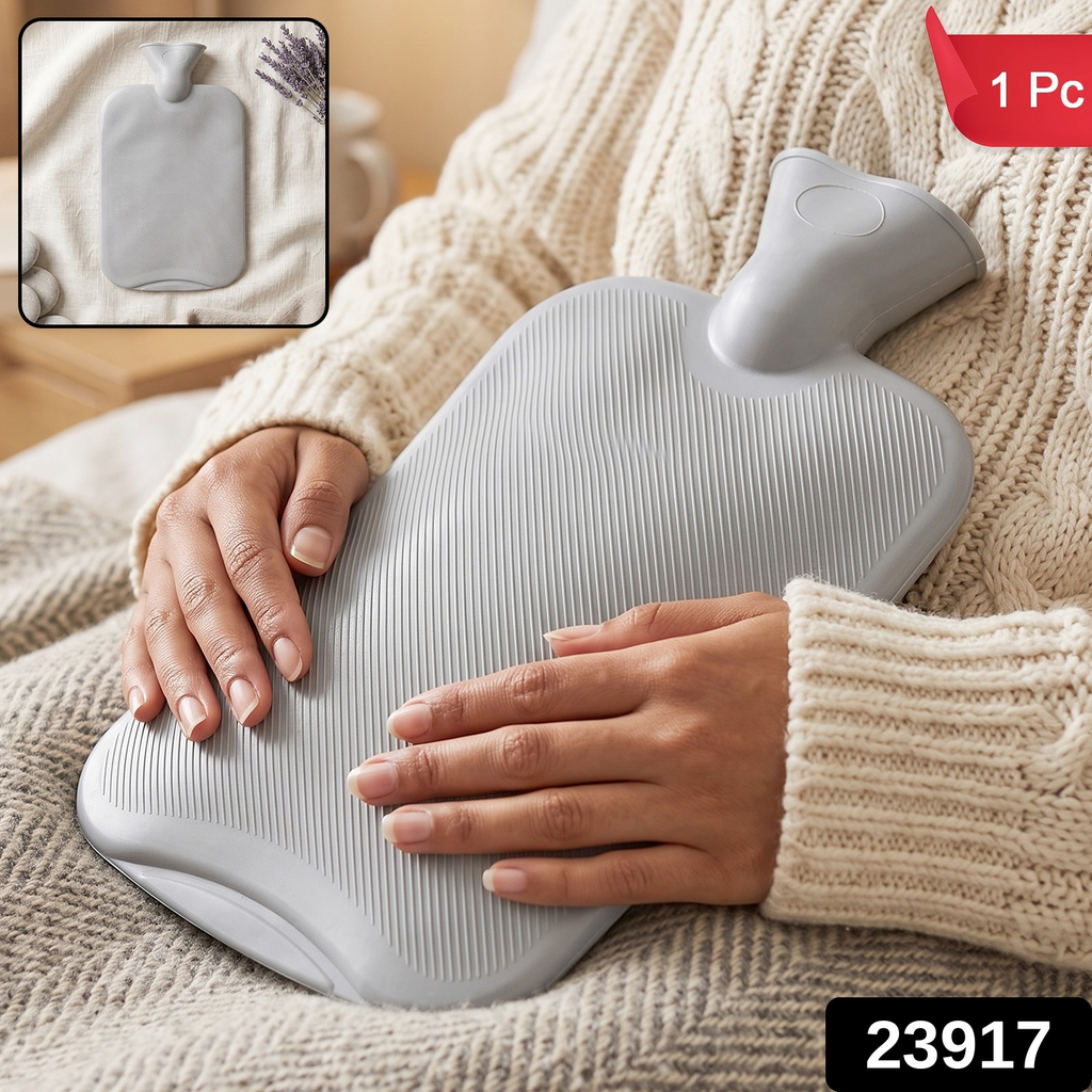 A person in a cream sweater holds a grey ribbed hot water bottle on their lap. The image has a red banner with '1 Pc' and a