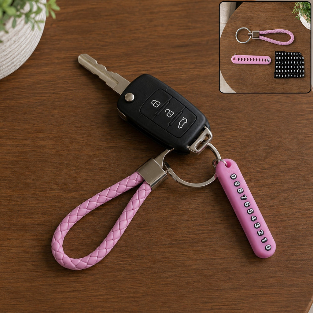 A pink braided wrist loop keychain with a car key and a pink number tag on a wooden table.