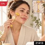 A woman in a white robe gently rolls a yellow jade massager across her cheek, with an inset showing the product.