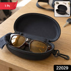 An open black hard shell sunglasses case with brown sunglasses and a black cleaning cloth inside, on a wooden table