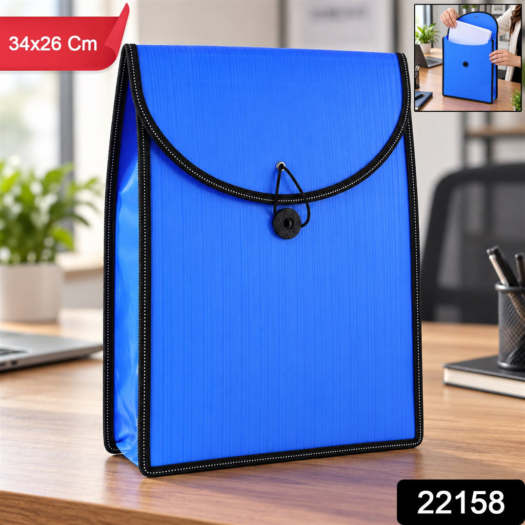 A blue plastic folder with a black elastic closure, standing on a wooden desk, with a laptop and plant in the background.