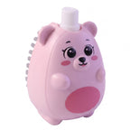 A pink bear-shaped soap dispensing brush with grey bristles on its side is shown on a white background.