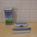 The cleaning tool components, including the head, handle parts, and packaging, are displayed on a wooden surface.