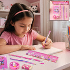 A young girl with dark hair writing in a notebook with a pink pen, surrounded by the matching stationery set on a table.