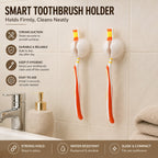 Two white toothbrush holder clips on a tiled wall, each holding a toothbrush, with text highlighting features like strong