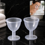 Two transparent eye wash cups with contoured rims and stable bases on a dark marble countertop, with an inset image of a