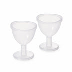 Two identical clear plastic eye wash cups with short stems and wide bases are displayed side-by-side on a plain white