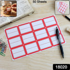 A sheet of 12 red-bordered white writable labels on a wooden desk with a pen, paper clips, and a jar of cookies.