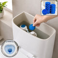 A hand places a blue toilet cleaner tablet into a toilet tank, with an inset showing a blue toilet bowl.