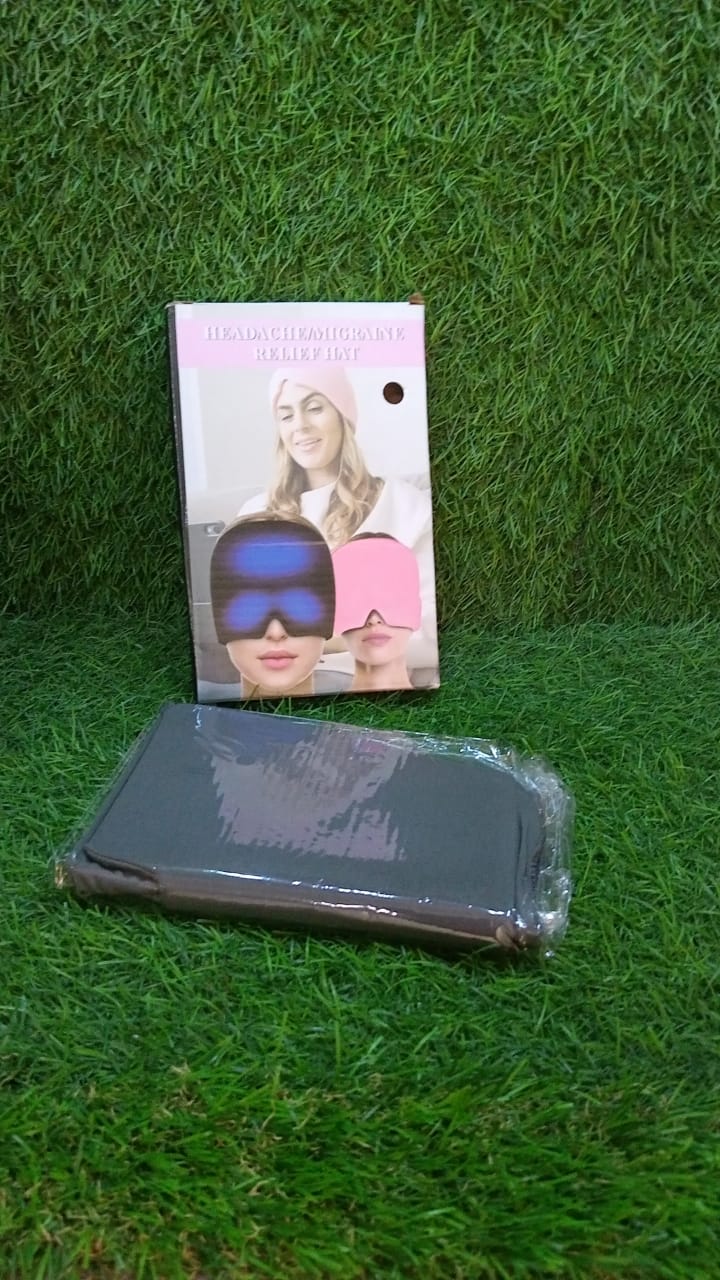 A black migraine relief cap in plastic packaging next to its product box, both resting on a green artificial grass surface.