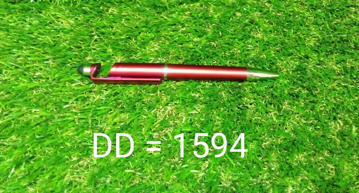 A red 3-in-1 stylus pen with a phone stand feature lying on green artificial grass.