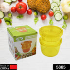 A yellow plastic manual food grinder sits next to its green and white box, labeled "Multifunctional Grinding Machine," with