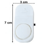 A white plastic magnetic door alarm is shown with its dimensions, 7 cm in length and 3 cm in width, indicated by arrows.