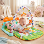 A happy baby on a green play mat with an arch of hanging toys, reaching for a toy, with a window and stuffed animals in the