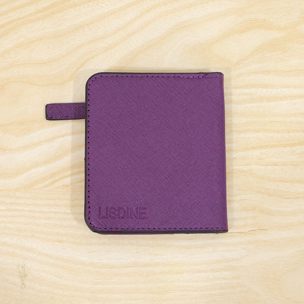 A closed purple bifold wallet with the brand name "LISDINE" embossed on the front, resting on a light wooden surface.