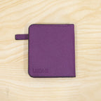 A closed purple bifold wallet with the brand name "LISDINE" embossed on the front, resting on a light wooden surface.