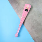 A closed pink fan with a white flower and