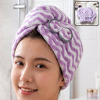 A woman with a purple and white chevron microfiber hair towel wrap on her head, secured with a grey bow.