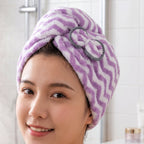 Close-up of a woman's face with a purple and white chevron microfiber hair towel wrap on her head.