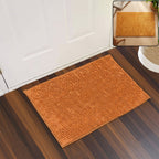 An orange bobble mat on a wooden floor, with a smaller inset image showing a similar mat's texture.