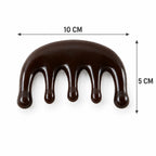 A dark brown resin scalp massager with five rounded prongs is shown with dimensions: 10 cm wide and 5 cm high.