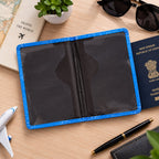 Open blue passport holder showing its empty black interior and clear pockets on a wooden surface.