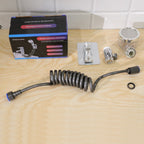 All components of the shower system, including the box, hose, spray head, and mounting bracket, are laid out on a wooden