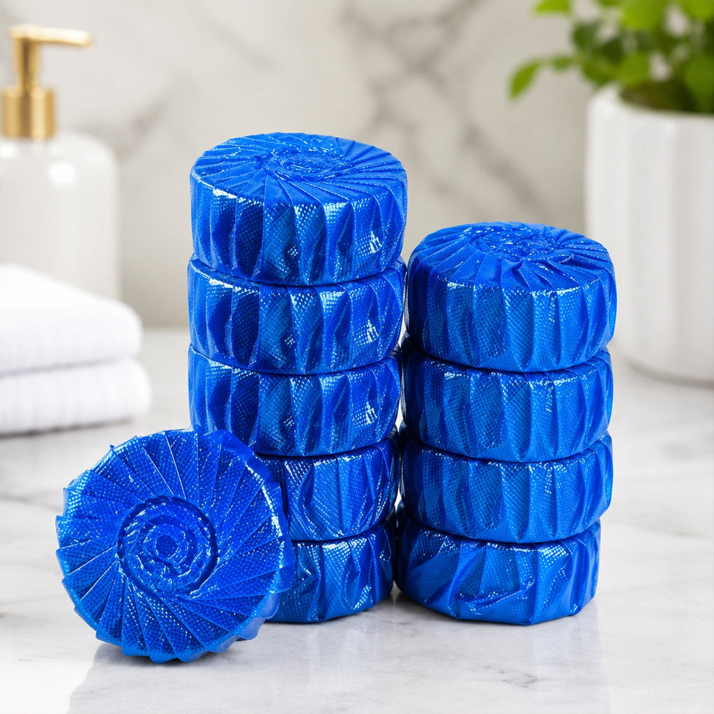 Two stacks of blue toilet cleaner tablets and one loose tablet are displayed on a marble surface in a bathroom setting.