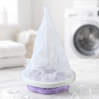 A purple and white floating lint mesh bag on a white counter with a washing machine in the background.