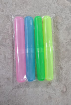 Four colorful toothbrush cases in pink, blue, green, and lime green, packaged together in clear plastic on a gray surface.