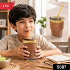 A young boy sips from an amber glass cup with a brown leather sleeve and a straw, with a '1 Pc' label.