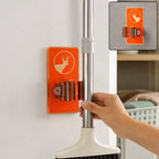 A hand placing a mop into an orange deer-themed wall-mounted holder on a white wall, with an inset showing the holder alone.