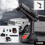 Black handheld vacuum cleaner expelling white mist, with various attachments and a charger displayed in the foreground, and