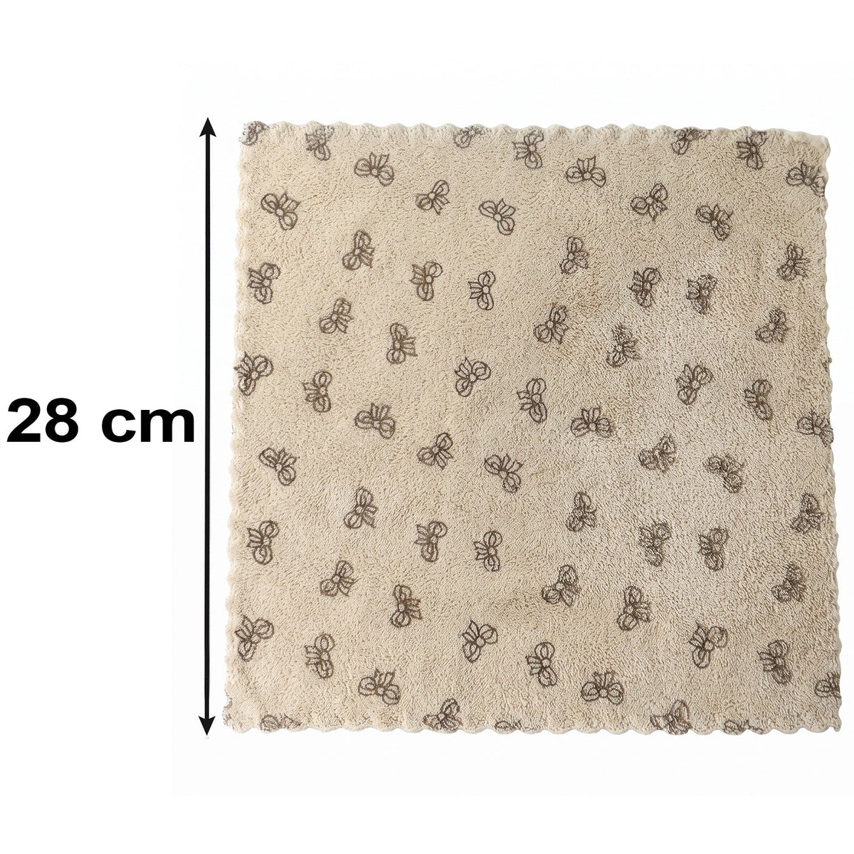 A beige microfiber towel with a dark bow pattern and scalloped edges lies flat on a white background, with a 28 cm