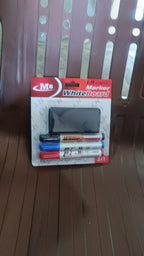 A packaged whiteboard marker set with three markers and a duster, resting on a brown slatted chair.