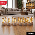 Twelve golden crescent moon LED tealights with warm glow on a wooden floor in living room.