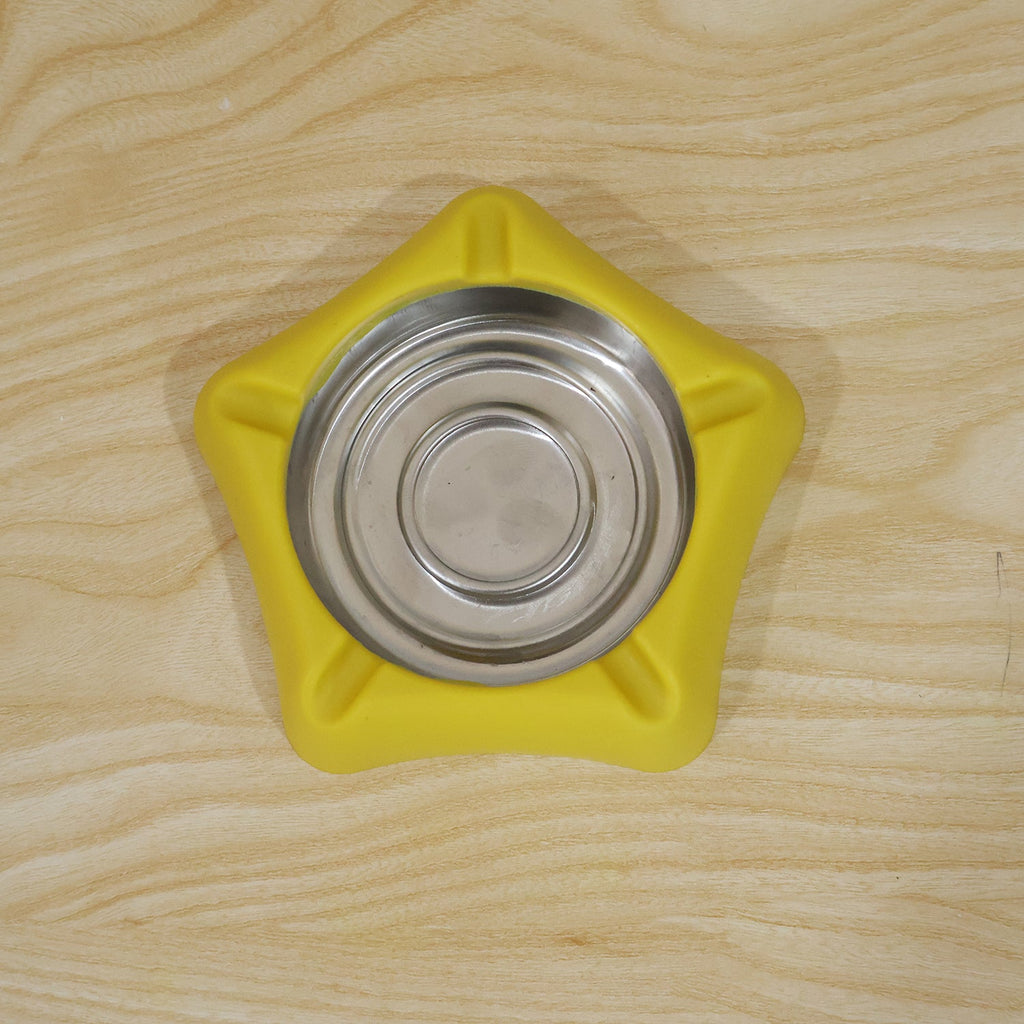 Top-down view of a yellow silicone ashtray with a stainless steel insert, resting on a light wooden surface.